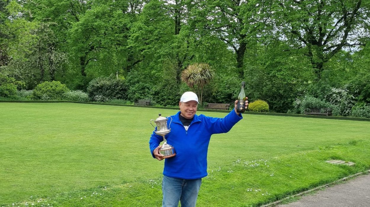 One of the winners of the Fixed Jack Triples holding a bottle of wine and a trophy